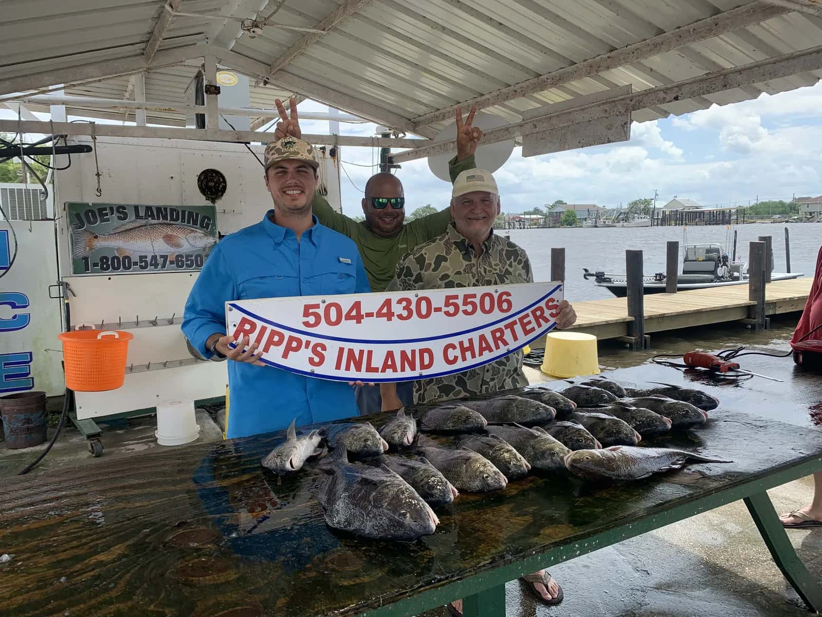 Anglers posing with a charter catch display