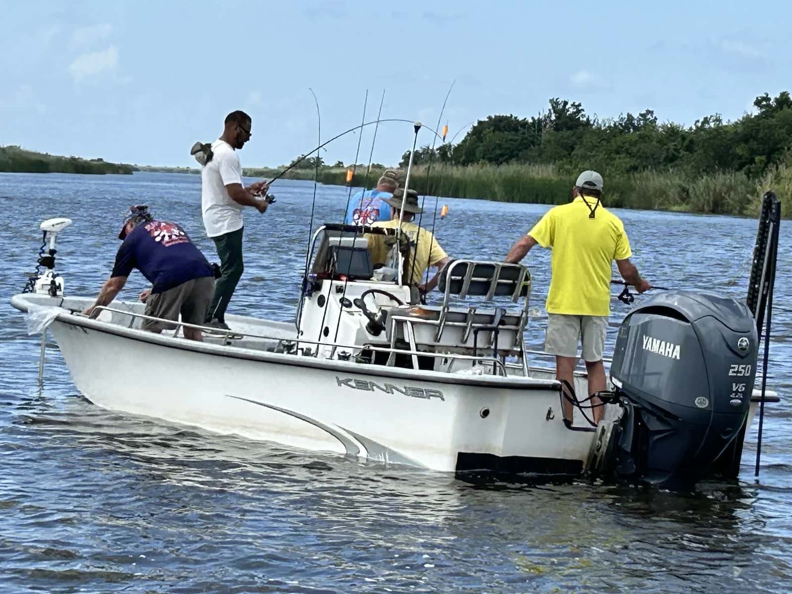 Fishing boat with anglers in broad coastal water