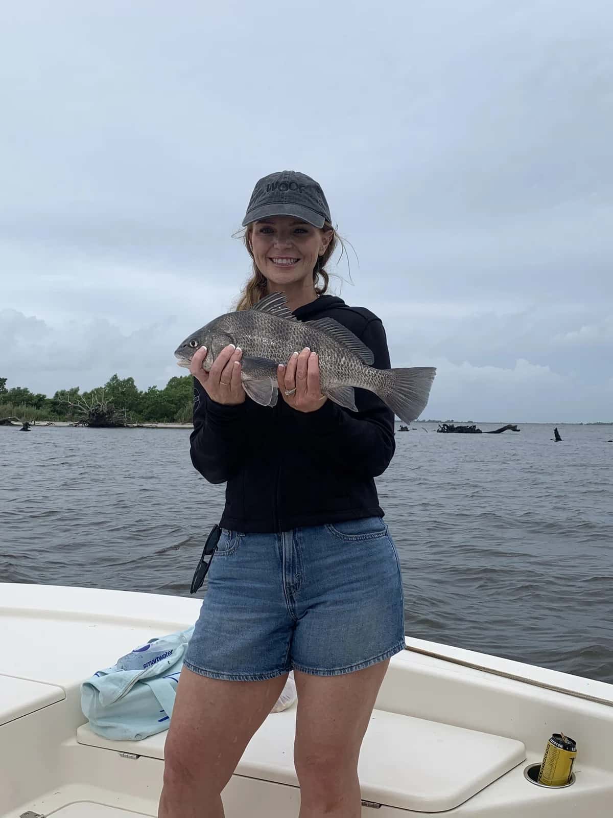 Smiling angler holding a fish aboard the boat