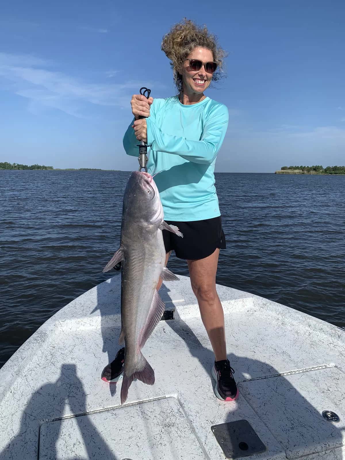 Angler holding a large fish on the bow of the boat