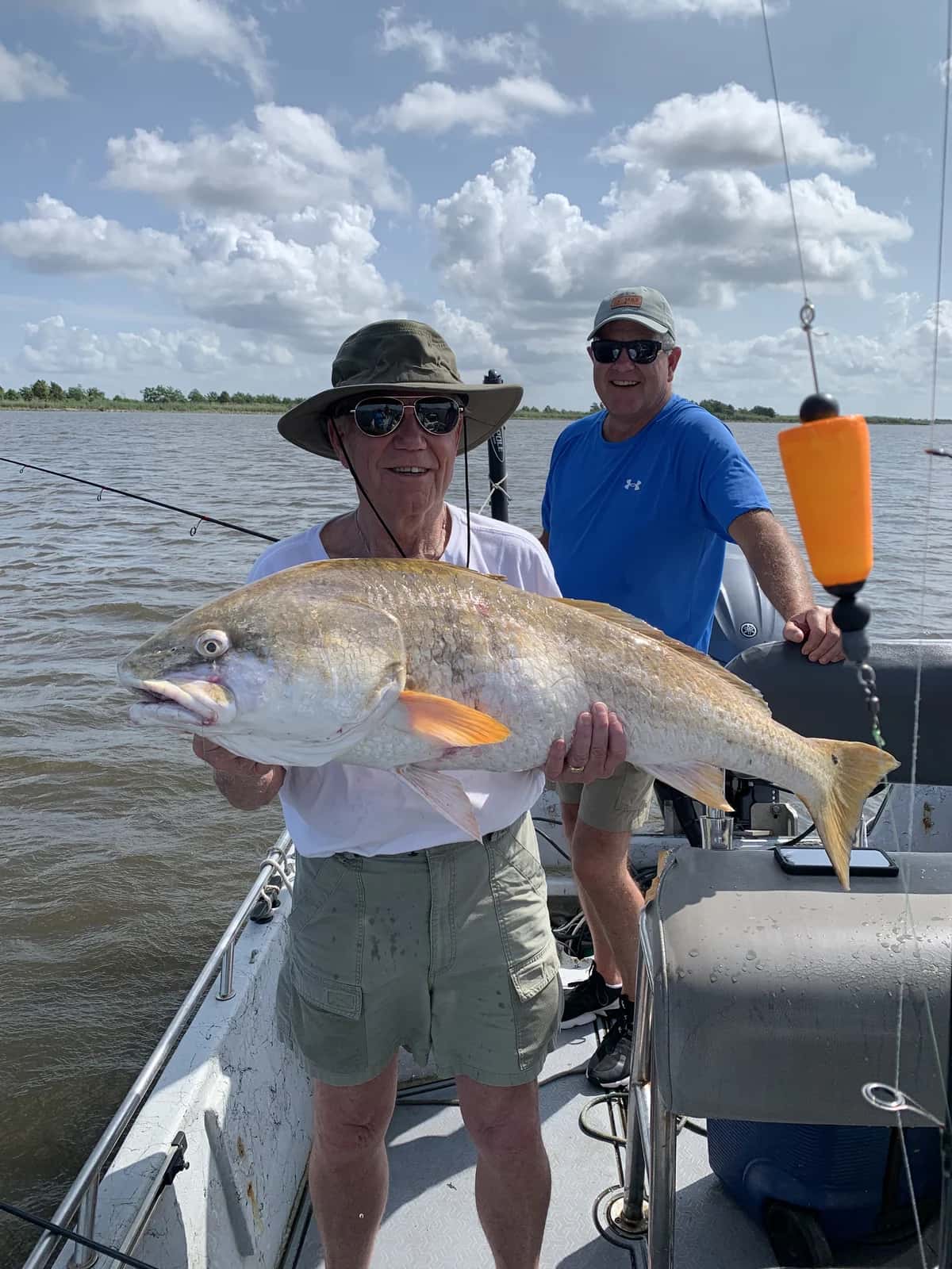 Angler presenting a large fish aboard the boat